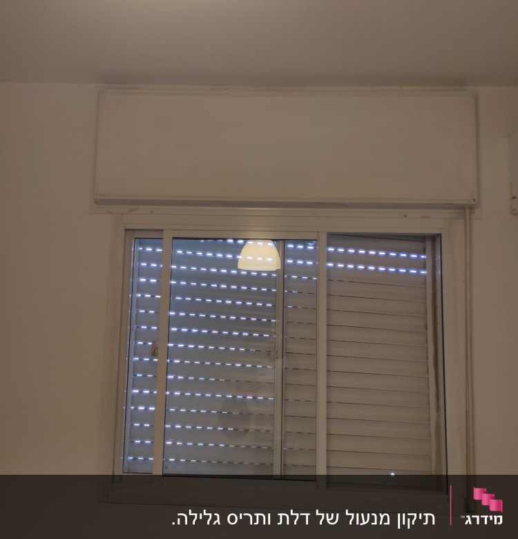 חלון עם תריסים סגורים ומסגרת לבנה